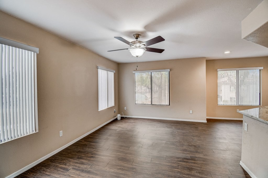 an empty living room with a ceiling fan and a window  at San Montego Apartments, Mesa, Arizona