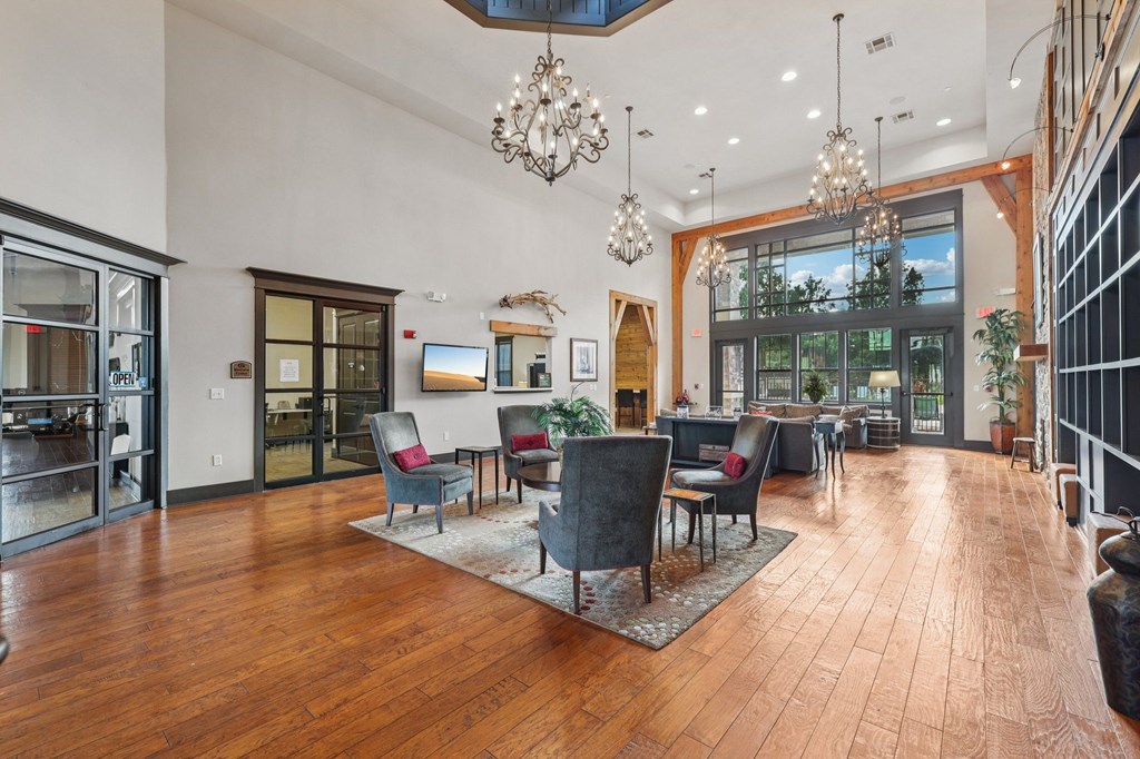 A large room with wooden floors and a chandelier hanging from the ceiling.