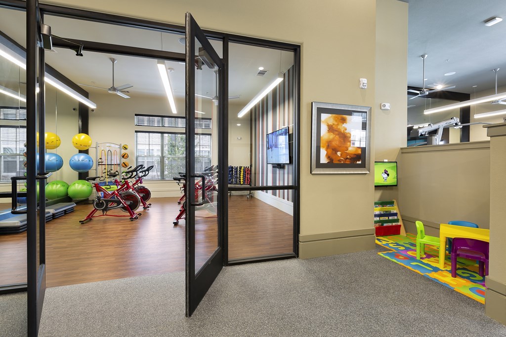 a gym with a variety of exercise equipment and glass doors at North Creek, Texas, 78634