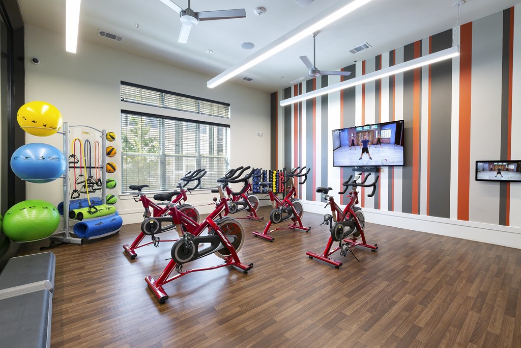 a fitness room with exercise equipment and a tv North Creek Apartments, Hutto, Texas