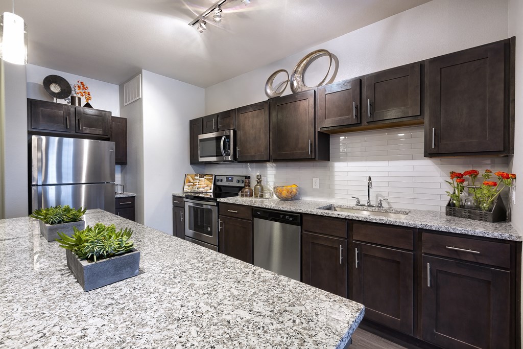 a kitchen with stainless steel appliances and granite counter tops at North Creek, Hutto