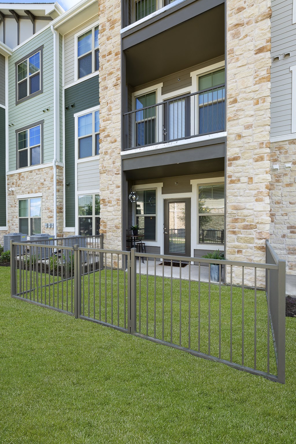 a metal fence in front of an apartment building at North Creek, Texas, 78634