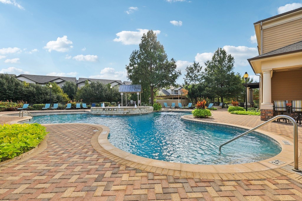 A swimming pool surrounded by a brick patio.