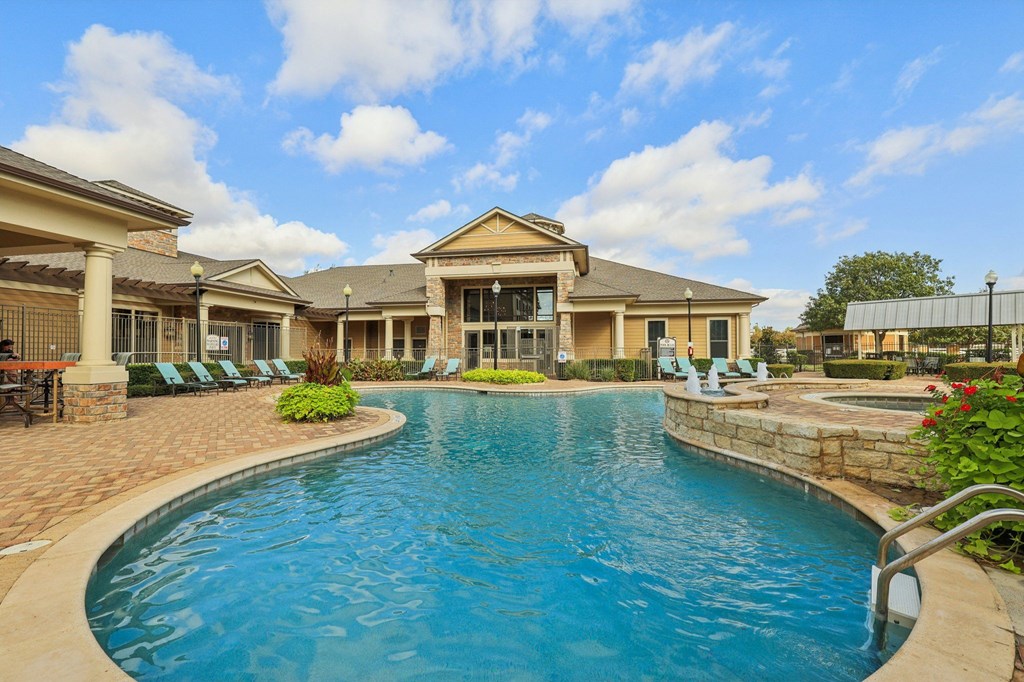A large swimming pool in front of a house.