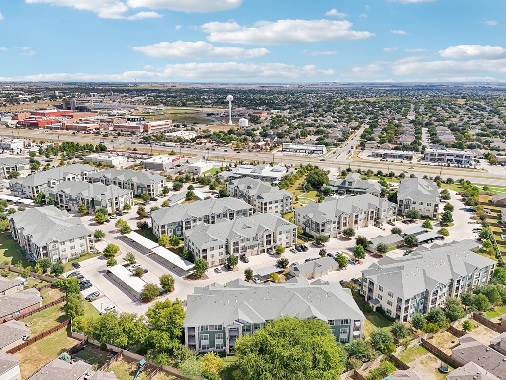 A bird's eye view of a residential area with multiple houses and a road.