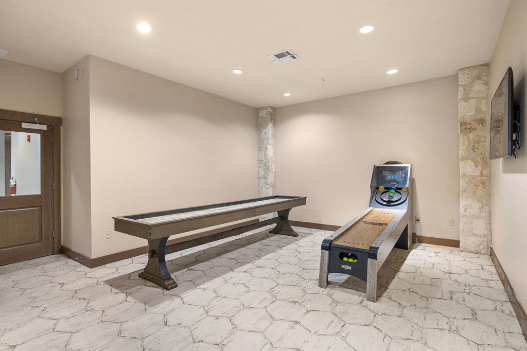 a game room with a shuffleboard table and a bench at Lakeline East Apartments, Texas, 78613