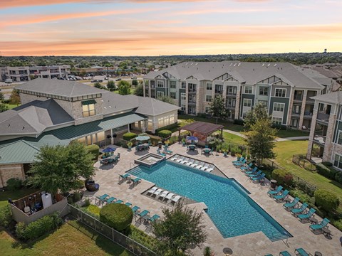 A large outdoor swimming pool surrounded by lounge chairs and umbrellas.at North Creek, Hutto