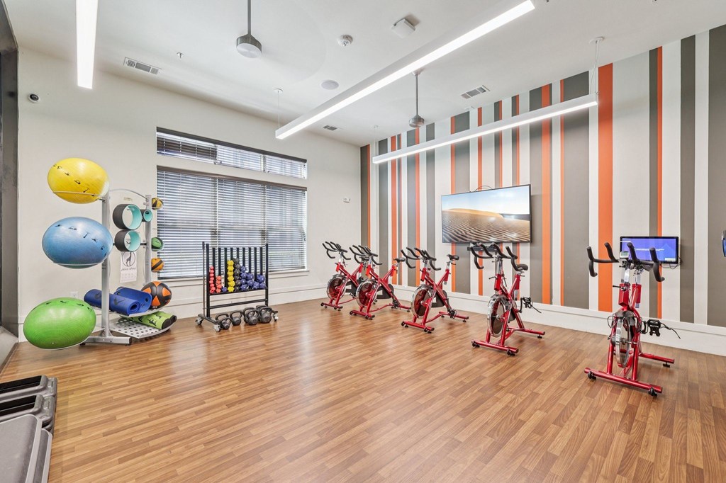 A gym with exercise equipment and a TV.