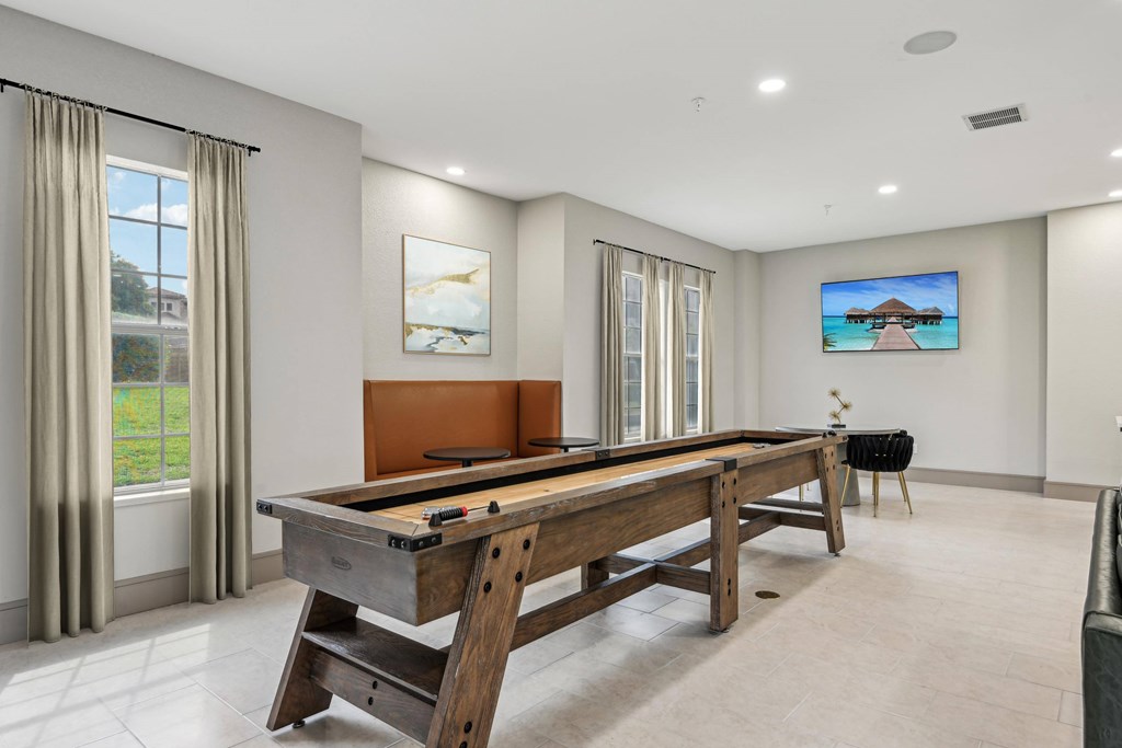 A pool table in a room with a television on the wall.
