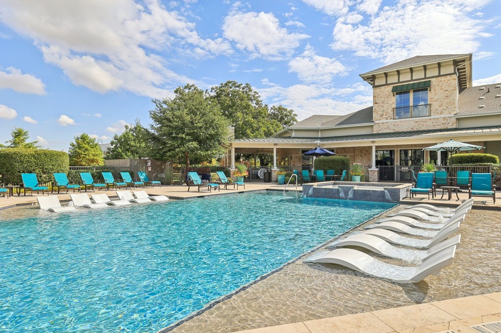 A large swimming pool with a building in the background.