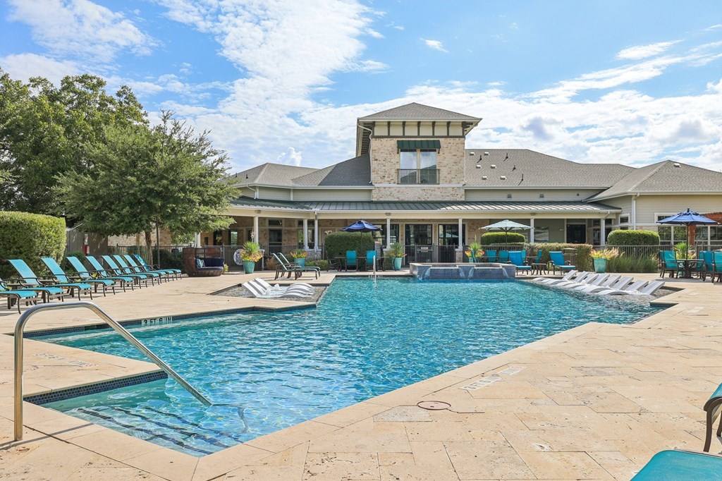 A large swimming pool with a building in the background.