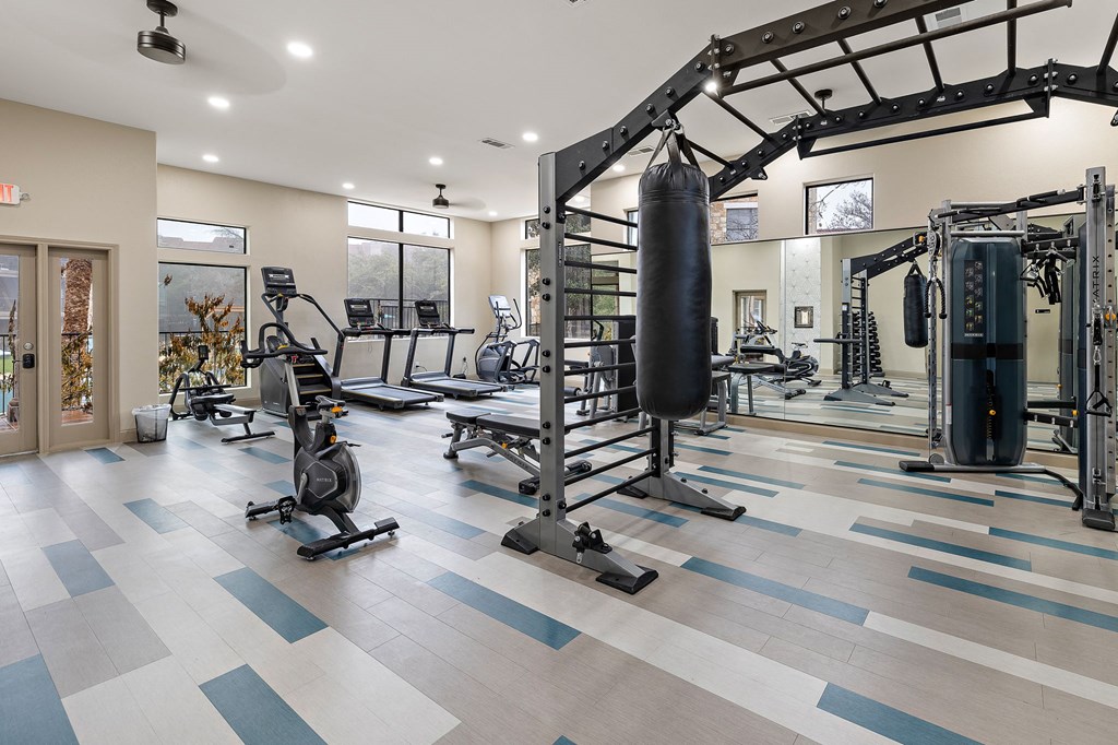 a gym with weights and cardio equipment and a punching bag at Waters Edge Apartment Homes, Georgetown, Texas