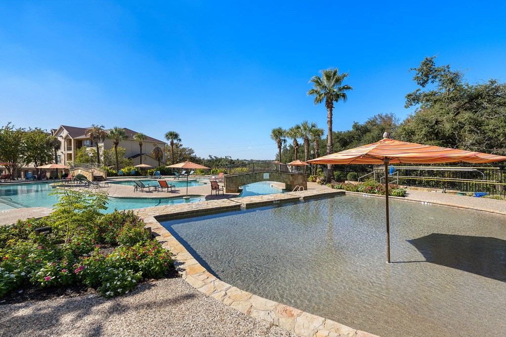 a swimming pool with umbrellas and a resort style pool at The Verandah, Austin, TX, 78726