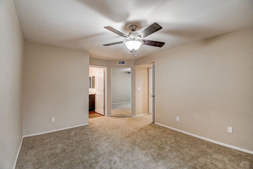 an empty living room with a ceiling fan  at San Montego Apartments, Mesa