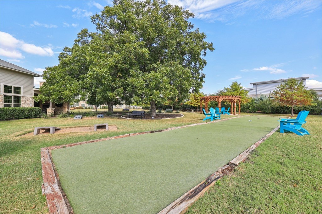A green lawn with a red border and a blue chair.