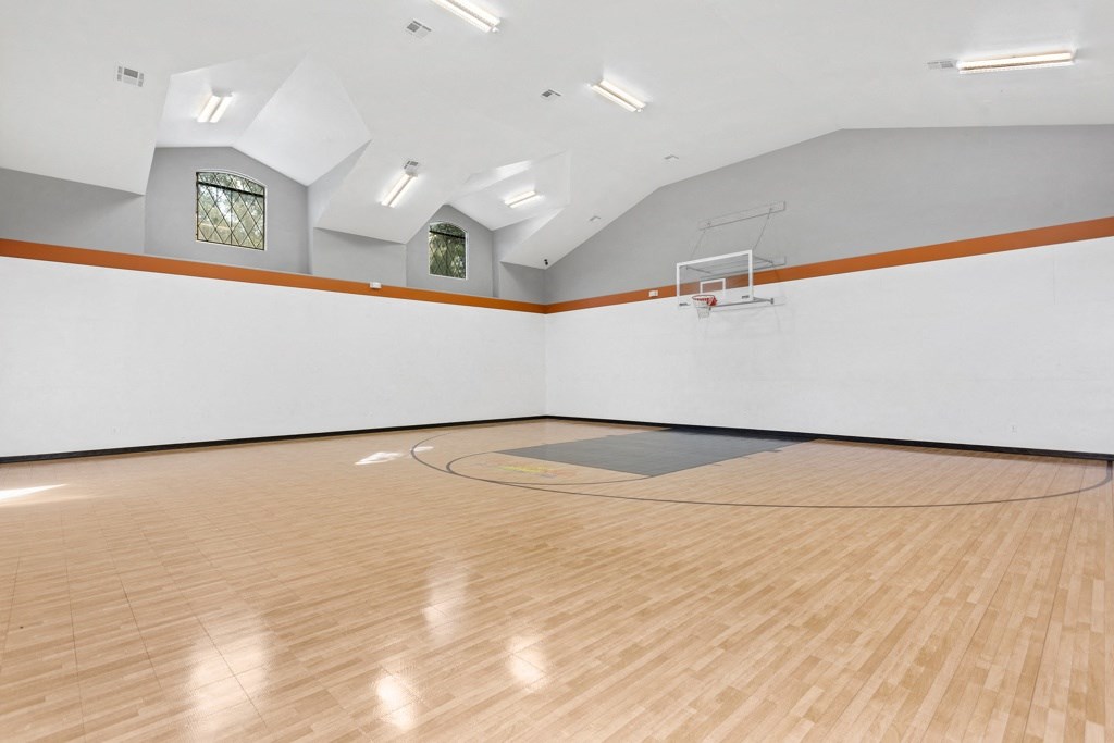 a large white room with a basketball hoop and a hardwood floor at The Verandah, Austin, Texas