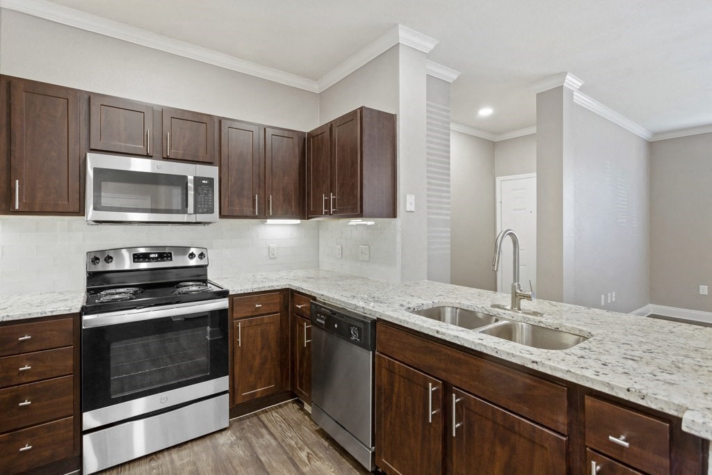 a kitchen with dark wood cabinets and white countertops at The Verandah, Texas