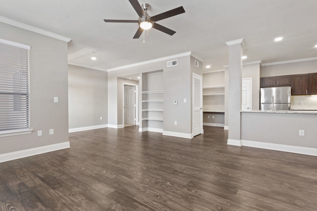 a living room with a ceiling fan and a kitchen in the background at The Verandah, Austin, 78726