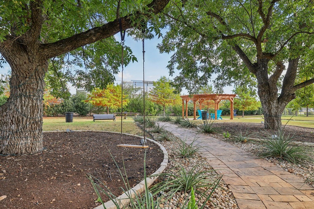 A park with a swing set and a bench.