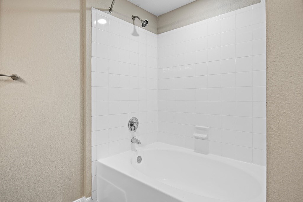 a bathroom with a garden bathtub and shower at Artisan Apartments & Shops, Austin, Texas