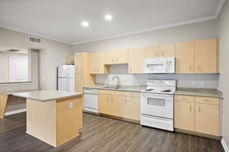 a kitchen with white appliances and wooden cabinets open floor plan