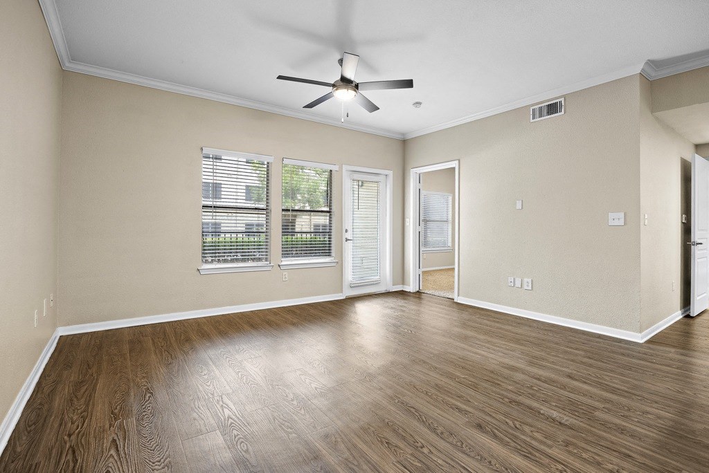 a living room with hardwood floors and a ceiling fans at Artisan Apartments & Shops