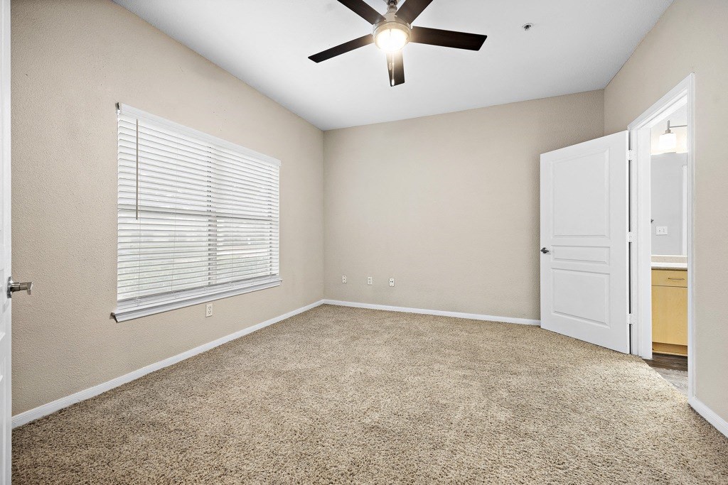 a bedroom with a ceiling fan and a window at Artisan Apartments & Shops, Austin, TX