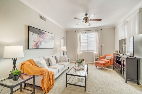 a living room with a white couch and a ceiling fan