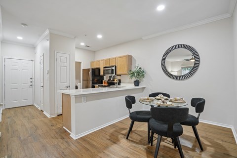 A kitchen with a dining table and chairs.