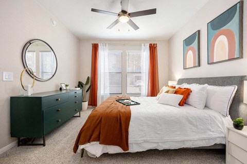 Spacious bedroom with teal dresser and artwork at Las Brisas Apartments, Round Rock