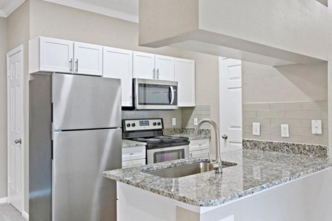 a kitchen with stainless steel appliances and granite counter tops