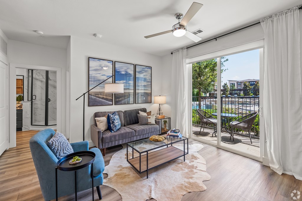 A modern living room with a blue armchair and a glass coffee table.