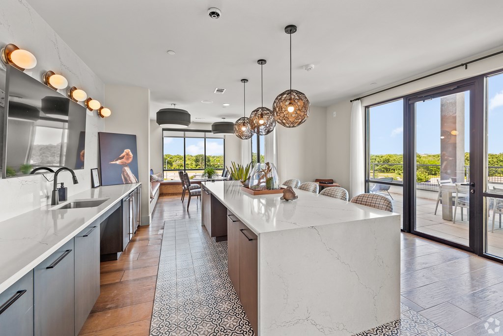 A modern kitchen with a large island and a view of the outdoors. at Aurora Watson Branch, Texas