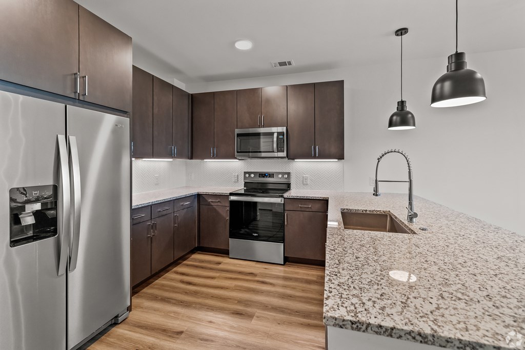 A modern kitchen with a refrigerator, microwave, oven, sink, and dishwasher. at Aurora Watson Branch, Texas, 76063