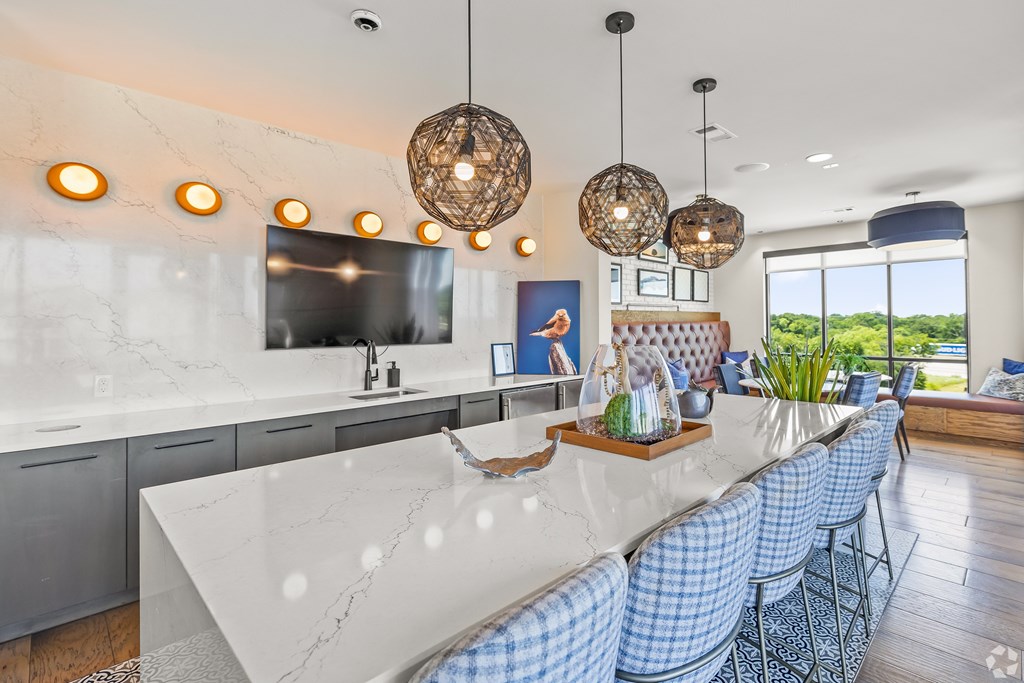 A modern kitchen with a marble countertop and blue chairs. at Aurora Watson Branch, Mansfield, 76063