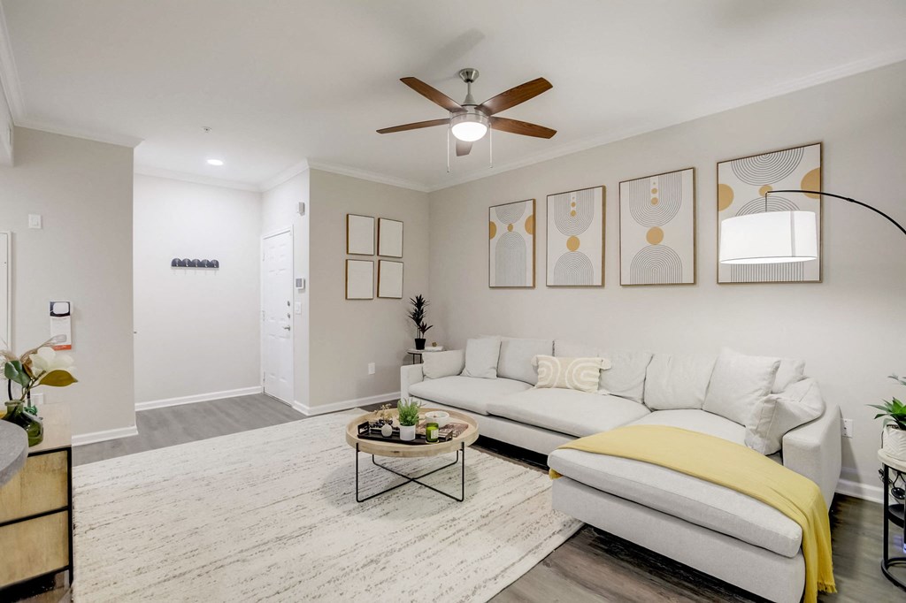 a living room with a white couch and a ceiling fan
