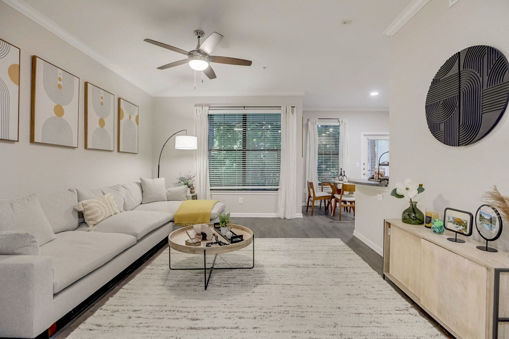 a living room with a white couch and a ceiling fan
