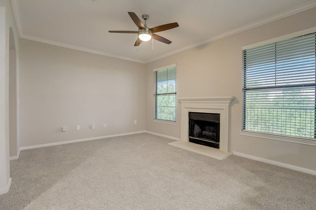 the living room has a fireplace and a ceiling fan