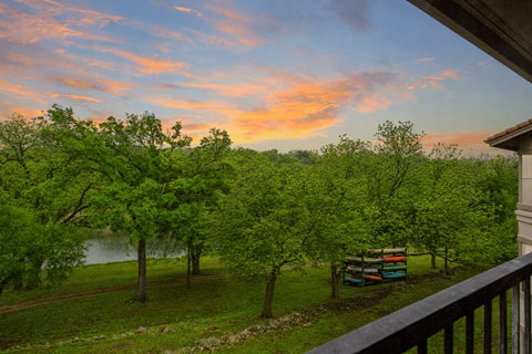 A beautiful view of a lake surrounded by trees and a bench.