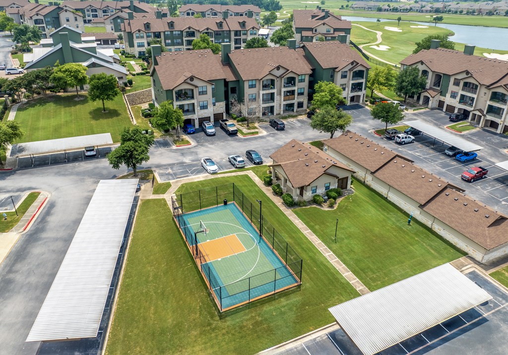 an aerial view of a basketball court in front of apartments
