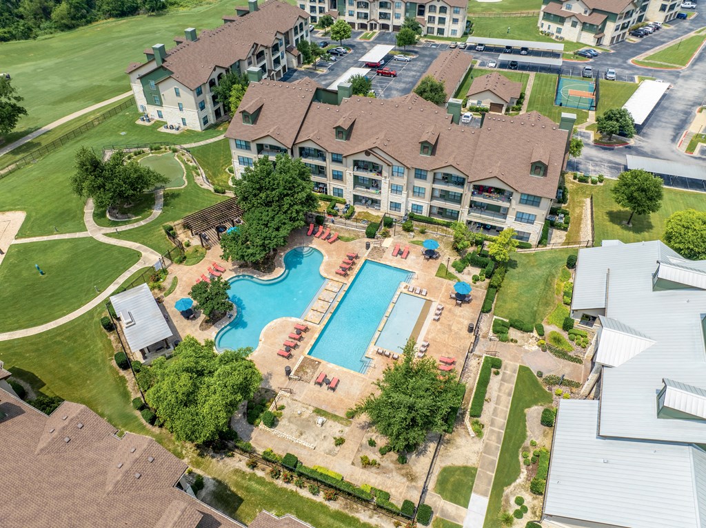 an aerial view of a large swimming pool in a neighborhood with houses