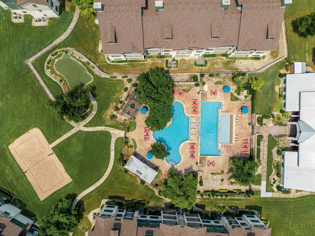 arial view of a swimming pool in a residential neighborhood with houses and trees