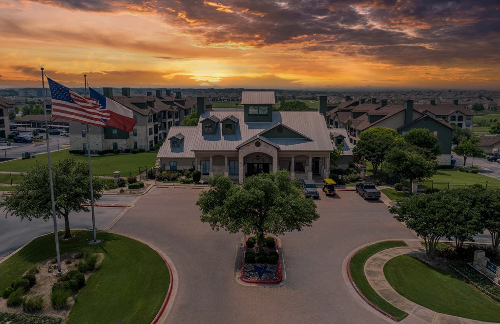 an aerial view of a building with an flag at sunset