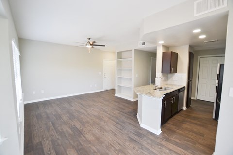 Beautiful upgraded kitchen with stainless steel appliances, granite countertops and walnut brown cabinetry, large open floorplan with built in bookshelves located  at The Legends at Eagle Mountain Lak