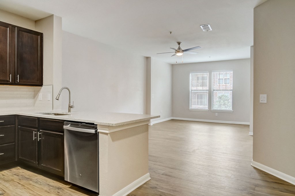 an empty kitchen and living room with a ceiling fan