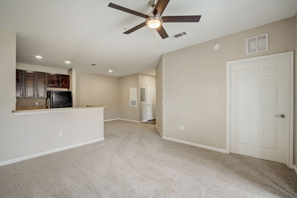 the living room and kitchen in a new home with a ceiling fan