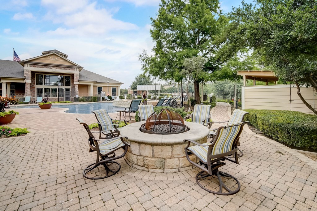 an outdoor patio with a fire pit and chairs