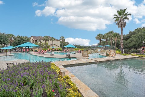a swimming pool with umbrellas at the resort at The Verandah, Austin