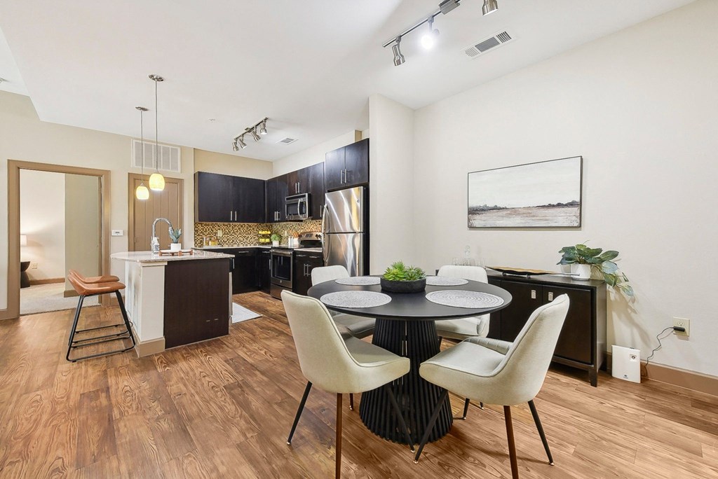 a dining room and kitchen with a table and chairs at Lakeline East Apartments, Cedar Park, TX