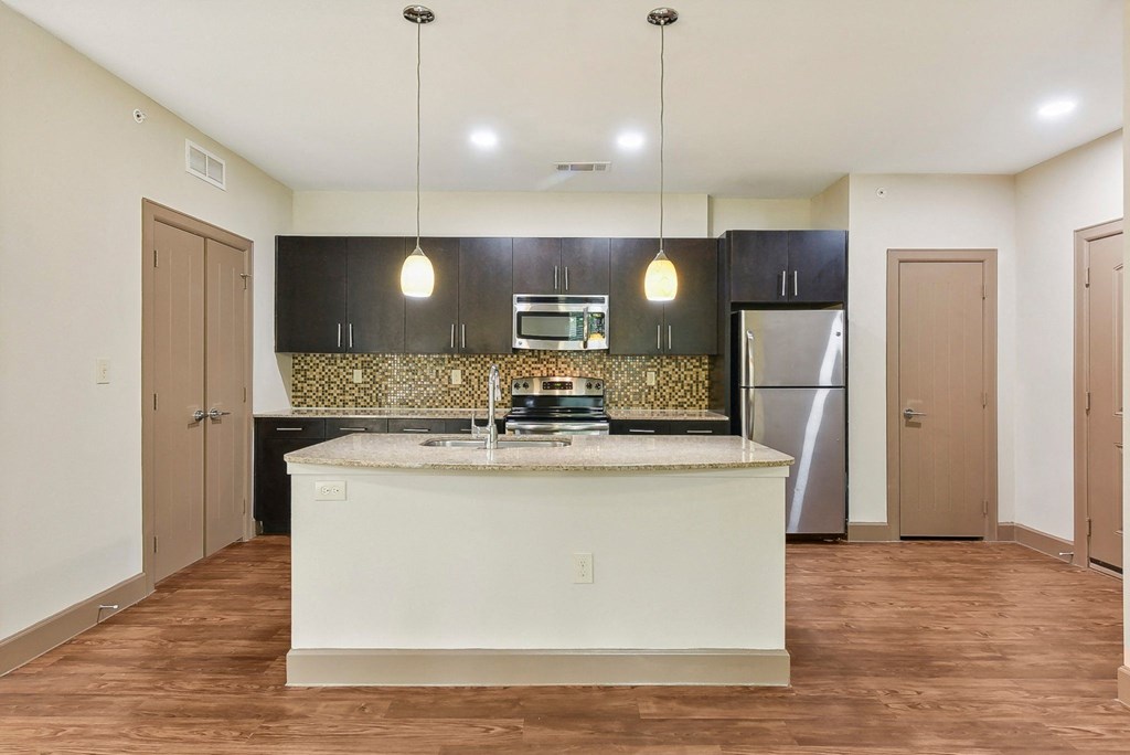 a kitchen with a large island and a stainless steel refrigerator at Lakeline East Apartments, Cedar Park, 78613